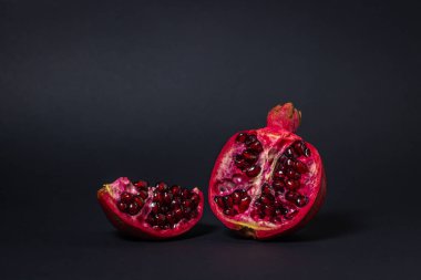 Siyah arka planda nar. Narı kes. Kırmızı meyve