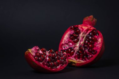 Siyah arka planda nar. Narı kes. Kırmızı meyve