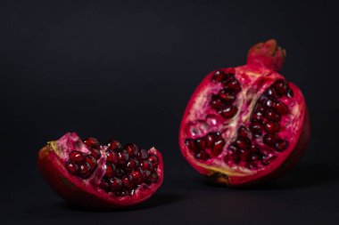 Siyah arka planda nar. Narı kes. Kırmızı meyve