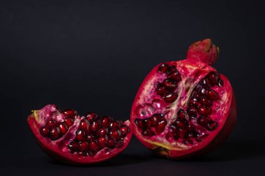 Siyah arka planda nar. Narı kes. Kırmızı meyve