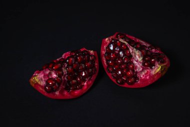 Siyah arka planda nar. Narı kes. Kırmızı meyve