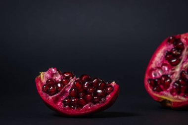 Siyah arka planda nar. Narı kes. Kırmızı meyve