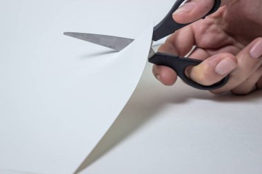 Makas beyaz kağıdı kesmiş. Kağıt ile çalışmak.