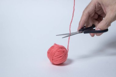 Beyaz arka planda pembe iplik yumağı. Makas ipliği kesti. Tekstil ürünü. Yazıt ya da logo için bir yer var..