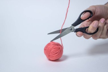 Beyaz arka planda pembe iplik yumağı. Makas ipliği kesti. Tekstil ürünü. Yazıt ya da logo için bir yer var..