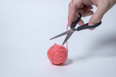 Beyaz arka planda pembe iplik yumağı. Makas ipliği kesti. Tekstil ürünü. Yazıt ya da logo için bir yer var..