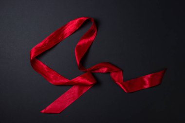 Siyah arka planda kırmızı kurdele. Yazı ve logo için arka plan. Tekstil malzemesi