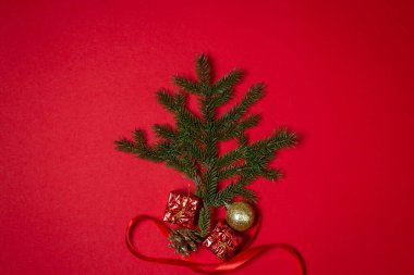 Kırmızı arka planda Noel süslemeleri olan Noel ağacı dalları. Noel arkaplanı. Yeni yıl kavramı.