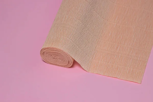 色のついた段ボール紙 ピンクの背景にベージュの段ボール紙のロール 紙製品 — ストック写真