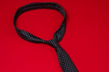 Siyah erkek kravatı. Kırmızı arka planda kravat. Erkek tarzı. Klasik erkek modası.