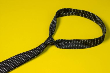 Siyah erkek kravatı. Sarı arka planda kravat. Erkek tarzı. Klasik erkek modası.