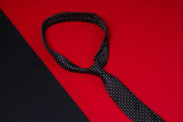 Black men's tie. Tie on a geometric background. Male style. Classic men's fashion