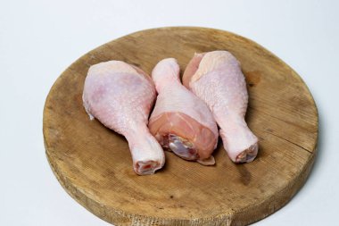 Tahtada çiğ tavuk bacağı. Beyaz arka planda tavuk bacağı. Tavuk eti.