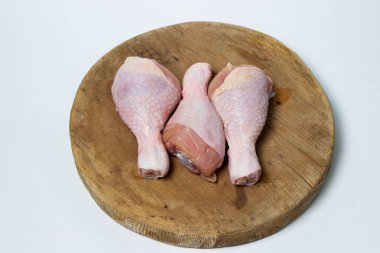 Tahtada çiğ tavuk bacağı. Beyaz arka planda tavuk bacağı. Tavuk eti.