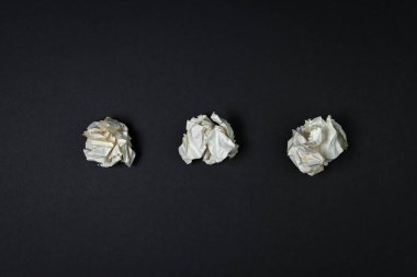 Siyah arka planda üç tane buruşuk kağıt. Yaratıcı kriz. Fikir eksikliği. 