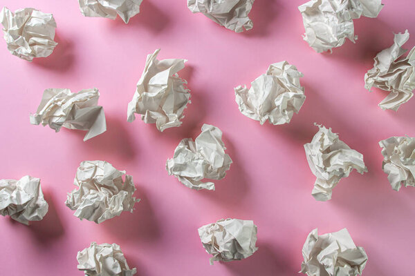 Crumpled paper on a pink background. A pile of crumpled paper. Creative crisis. Lack of ideas