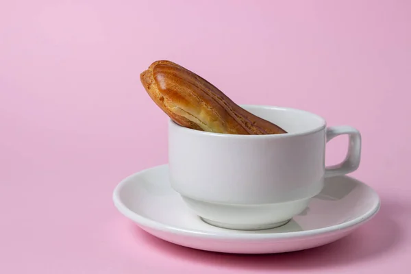 Eclairs Sobre Fondo Rosa Una Eclair Una Taza Desayuno Dulce —  Fotos de Stock