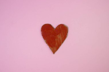 Pembe arka planda karton bir kalp. Yanlış boyanmış bir kalp. Kırmızı kalp. Sağlık kavramı