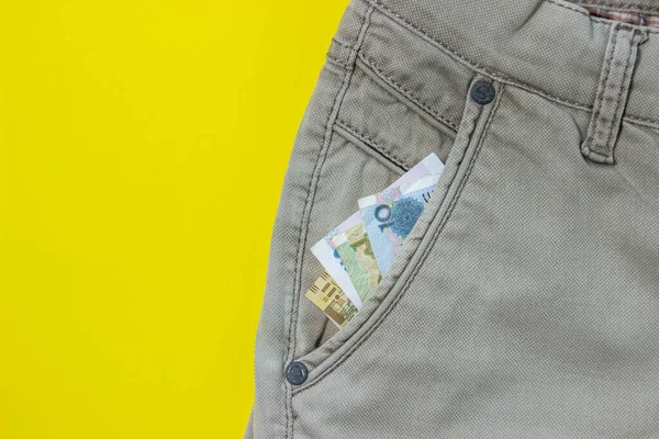 Faturalar Pantolon Cebinden Çıkıyor Kağıt Para Sarı Arka Planda Giysiler — Stok fotoğraf
