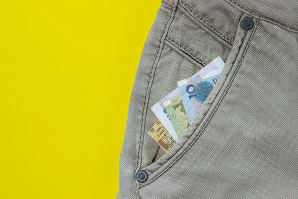 手形はズボンのポケットから突き出している 紙幣だ 黄色の背景の服 — ストック写真