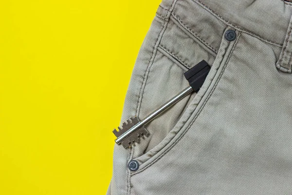 鍵はズボンのポケットから突き出している 家の鍵 黄色の背景の服 — ストック写真