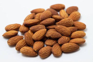 Beyaz arka planda badem. İzole bademler. Kavrulmuş badem yığını