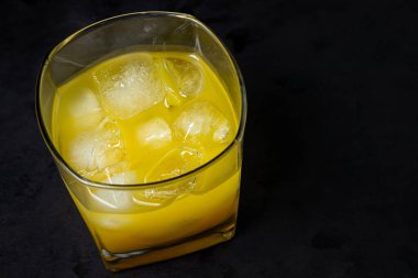 Siyah arka planda buzlu meyve suyu. Doğal mango suyu. Tazeleyici içecek.