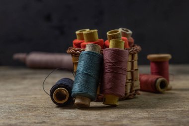 Ahşap bir yüzeyde eski renkli iplik makaraları. Dikiş için renkli iplik.