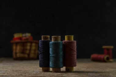 Ahşap bir yüzeyde eski renkli iplik makaraları. Dikiş için renkli iplik.
