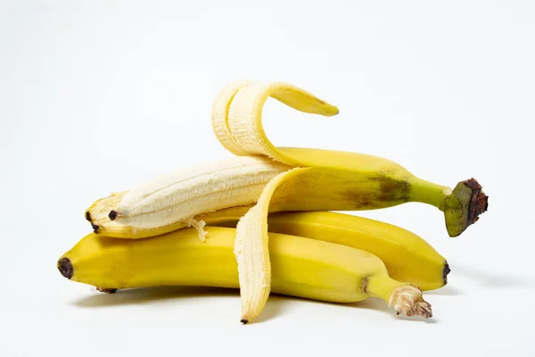 白色背景的香蕉 新鲜的黄色香蕉 一个剥皮的香蕉放在整个香蕉的顶部 异国水果 — 图库照片