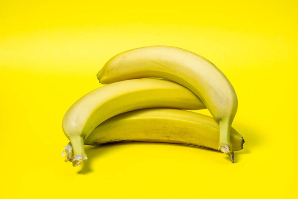 Bananas on a yellow background. Fresh yellow bananas. Bananas are on top of each other. Exotic fruit