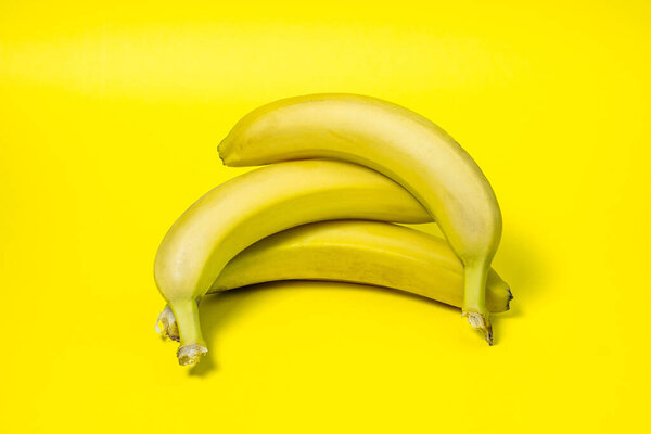 Bananas on a yellow background. Fresh yellow bananas. Bananas are on top of each other. Exotic fruit