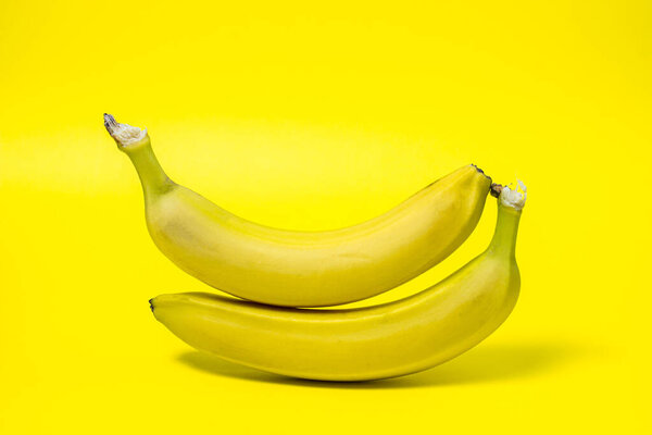 Bananas on a yellow background. Fresh yellow bananas. Bananas are on top of each other. Exotic fruit