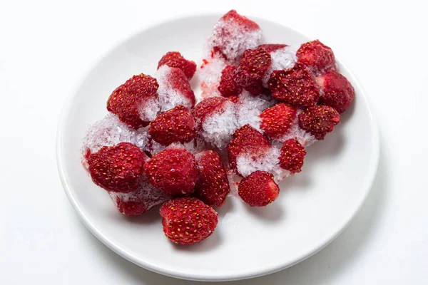 白盘上的冻草莓 草莓在白底冰上 冰冻浆果 — 图库照片