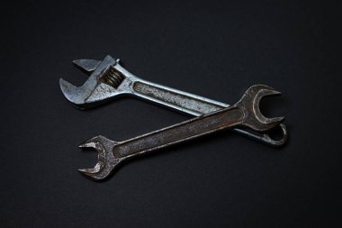Siyah arka planda İngiliz anahtarı ve ayarlanabilir anahtar. Eski çalışma aletleri. Çelik aletler