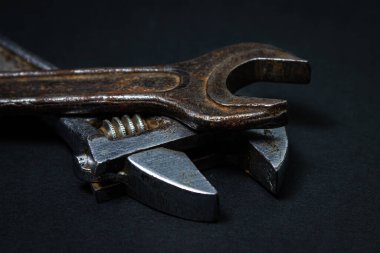 Siyah arka planda İngiliz anahtarı ve ayarlanabilir anahtar. Eski çalışma aletleri. Çelik aletler