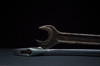 Siyah arka planda İngiliz anahtarı ve ayarlanabilir anahtar. Eski çalışma aletleri. Çelik aletler