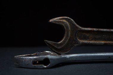 Siyah arka planda İngiliz anahtarı ve ayarlanabilir anahtar. Eski çalışma aletleri. Çelik aletler