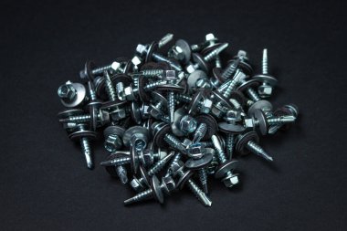 Çatı vidaları siyah arka planda. Metal yapı malzemesi. Metal için kendi kendine dokunan vidalar