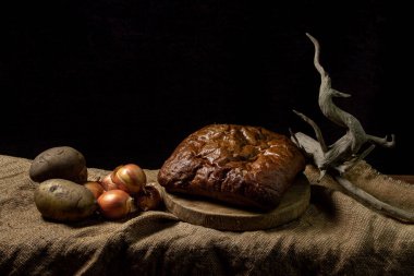 Siyah arka planda siyah ekmek ve sebzeler. Borodino ekmeği. Ev yapımı pişirme. Fırın ürünü. Köylü yemeği.