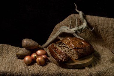 Siyah arka planda siyah ekmek ve sebzeler. Borodino ekmeği. Ev yapımı pişirme. Fırın ürünü. Köylü yemeği.