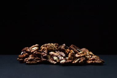 Siyah arka planda soyulmuş ceviz. Bir demet kabuklu ceviz. Besleyici yemekler.