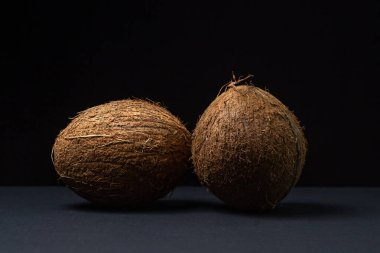 Siyah arka planda izole edilmiş hindistan cevizi. Koyu bir arka planda iki hindistan cevizi. Sağlıklı meyve