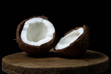 Siyah arka planda izole edilmiş hindistan cevizi. Karanlık bir arka planda hindistan cevizinin iki yarısı. Sağlıklı meyve