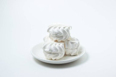 Beyaz arka planda marşmelov. Beyaz bir tabakta beyaz lokum. Hafif tatlı.