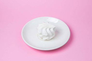 Pembe arka planda beyaz lokum. Beyaz bir tabakta beyaz lokum. Hafif tatlı.