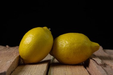 Koyu bir arka planda limon. Ahşap arka planda iki limon. Limonun yaratıcı fotoğrafı.