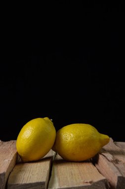 Koyu bir arka planda limon. Ahşap arka planda iki limon. Limonun yaratıcı fotoğrafı.