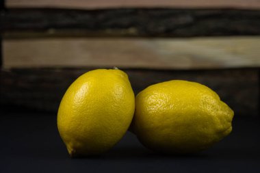 Koyu bir arka planda limon. Ahşap arka planda iki limon. Limonun yaratıcı fotoğrafı.
