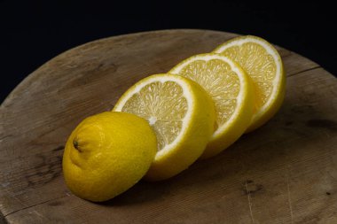Koyu bir arka planda limon. Ahşap arka planda dilimlenmiş limon. Limonun yaratıcı fotoğrafı.